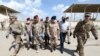 Iraqi Army officers wear protective masks, following the outbreak of coronavirus disease (COVID-19), as they walk with U.S. officers before a handover ceremony of K-1 airbase from U.S.-led coalition forces to Iraqi Security Forces. March 29, 2020