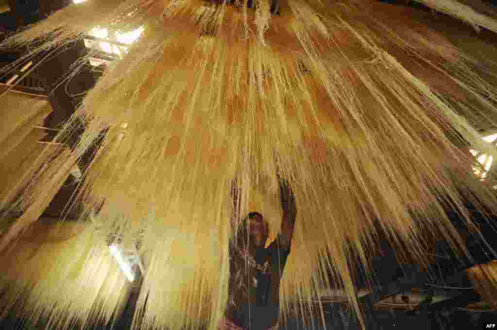 An Indian worker dries seviiyan (thin vermicelli), which is used for the preparation of the traditional sweet dish sheerkhurma by the Muslim community during the holy month of Ramadan, at a factory in Agartala. (AFP/Arindam Dey)