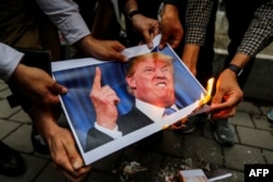 Iranians burn an image of U.S. President Donald Trump during a demonstration outside the former U.S. Embassy in Tehran following Washington's withdrawal from a nuclear deal in May 2018.