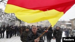 Georgia -- A supporter of South Ossetian Presidential candidate Alla Dzhioyeva waves the national flag during a meeting in Tskhinvali, 29Nov2011