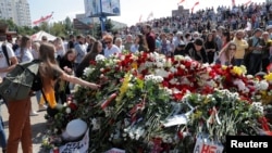 Ljudi polažu cvijeće i odaju počast demonstrantu Aleksandru Tarajkovskom, ubijenom tokom nedavnih demonstracija protiv rezultata predsjedničkih izbora, na mjestu njegove smrti u Minsku, Bjelorusija, 15. augusta 2020. godine
