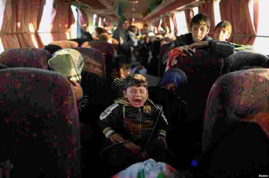 An Iraqi boy who just fled a village controlled by Islamic State fighters cries as he sits with his family inside a bus before heading to a camp for the displaced near Mosul. (Reuters/Zohra Bensemra)