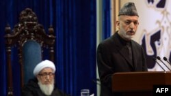 Afghan President Hamid Karzai (right) addresses the Loya Jirga on its opening day on November 21 as the council's head, Sibghatullah Mojaddedi, listens.