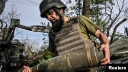 Боєць 44-ї ОАБр ЗСУ несе снаряд до самохідної гаубиці 2С22 «Богдана», Запорізька область, 25 травня 2026 року
