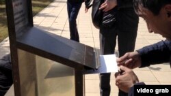 The activists placed their written demands to President Nursultan Nazarbaev in a mailbox in front of the building expressing their opposition to the launch of a Proton-M rocket from the Baikonur space center in Kazakhstan.