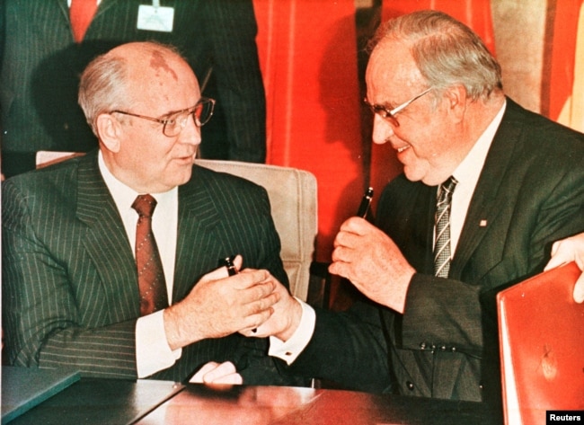 Радянський лідер Михайло Горбачов (ліворуч) та канцлер Німеччини Гельмут Коль обмінюються авторучками після підписання угоди в Бонні, листопад 1990 року