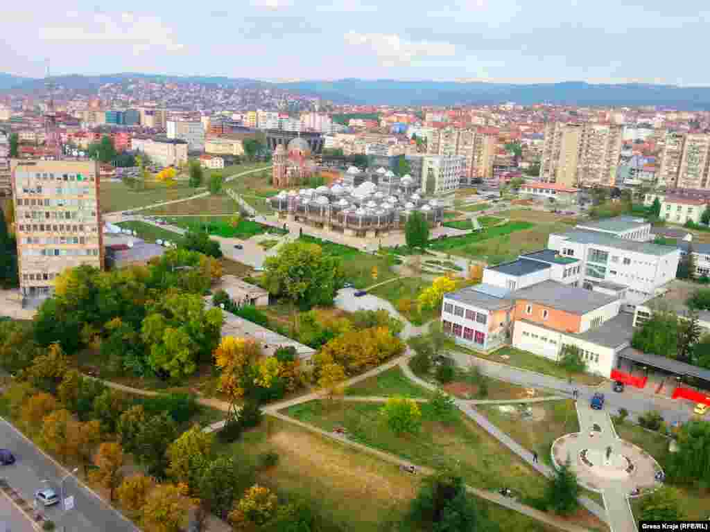 Pamje nga Prishtina ku shihet kisha në mes të hapësirës universitare.