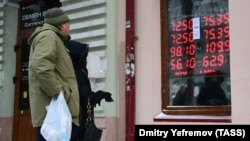 People look at an electronic board displaying currency exchange rates in Vladivostok on March 10.