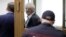 Frode Berg speaks with his lawyer from inside a glass cage in a courtroom in Moscow on April 16.