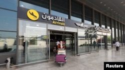 An Iranian passenger carrying luggage leaves Najaf International Airport after arriving on an AVA Airlines flight, in Najaf, Iraq on September 23.