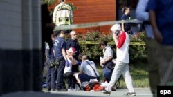 A person is treated by emergency workers as members of the Republican congressional baseball team look on following a shooting in Alexandria, Virginia, on June 14. 