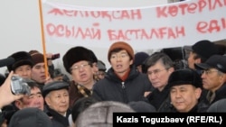 Лидеры и активисты оппозиционных движений выступают в Алматы в знак солидарности с бастующими Жанаозена. Позади держат транспарант "Так начинался Желтоксан". 17 декабря 2011 года.
