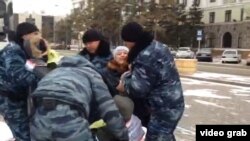 Полицейские задерживают участников акции протеста, требующих предоставления альтернативного жилья вместо сносимого. Астана, 11 ноября 2014 года.