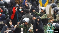 Riot police clash with opposition protesters in Tehran on November 4.