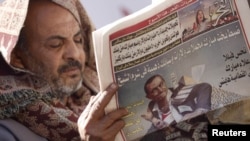 A man reads a local newspaper on Tahrir Square in Cairo.