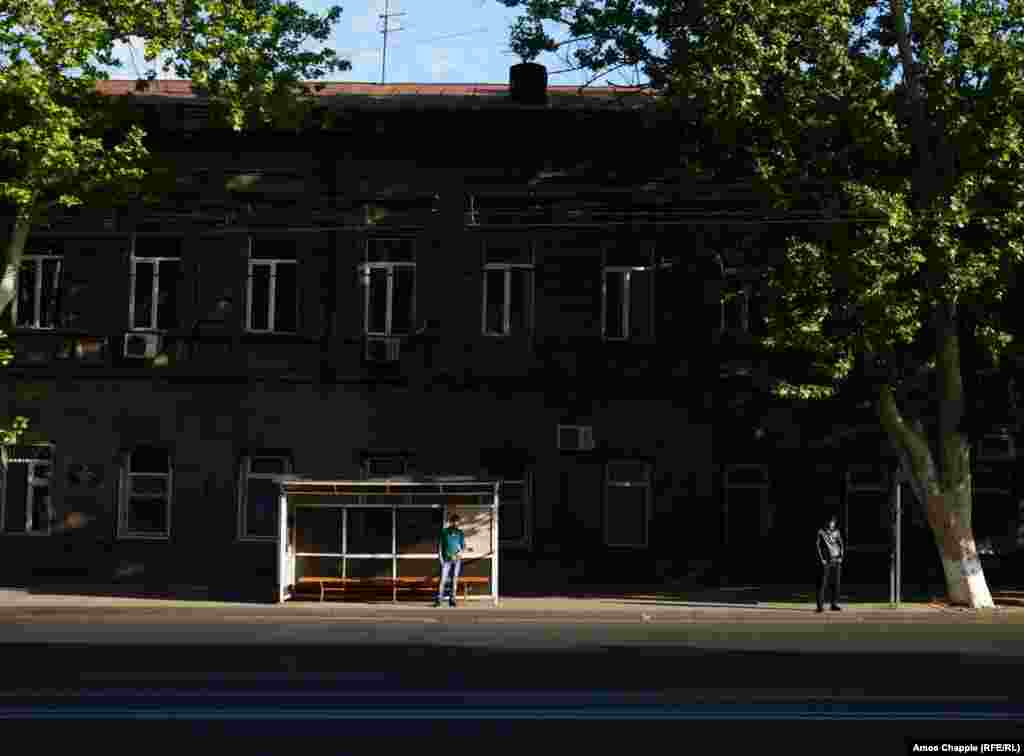 Two men wait for a bus in the morning light in central Yerevan.&nbsp;After weeks of protest that included nonviolent acts of dissent, there was almost no sign of the political crisis gripping Armenia.