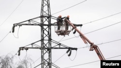 Workers restore a high-voltage line destroyed in a Russian missile attack in Kyiv. (file photo)