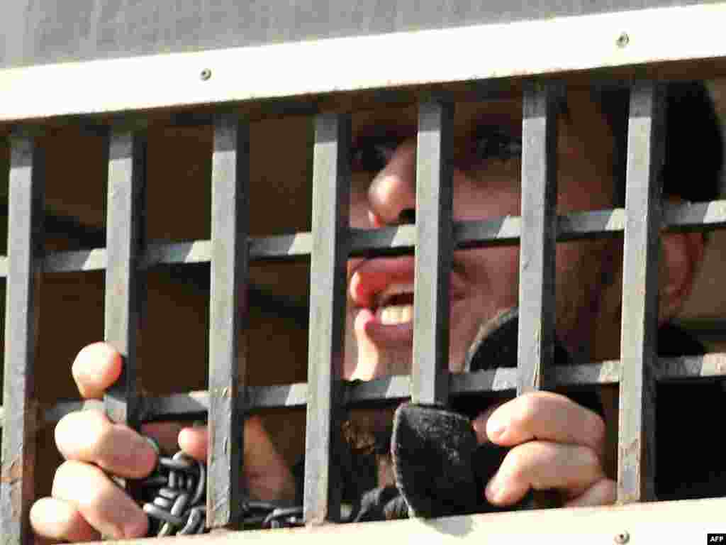 Pakistan -- US terror suspect, looks out of a prisoners van as they are brought to a court in Sargodha, 02Feb2010 - PAKISTAN, Sargodha : A US militant suspect shouts from a police prison van as he and others depart from an anti-terrorist court following a hearing in Sargodha on February 2, 2010. Five young American men detained in Pakistan for alleged links to Islamist extremist groups swore their innocence on February 2, saying they were being "set up" and tortured in jail. The men, aged between 18 and 25 and including two Pakistani-Americans, were arrested in Sargodha in December. They are accused of trying to contact Al-Qaeda-linked groups and plot attacks against Pakistan and its allies. AFP POTW05