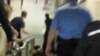 Скриншот появившегося в Интернете видео, в котором милиционеры тащат вниз по лестнице инвалида. 