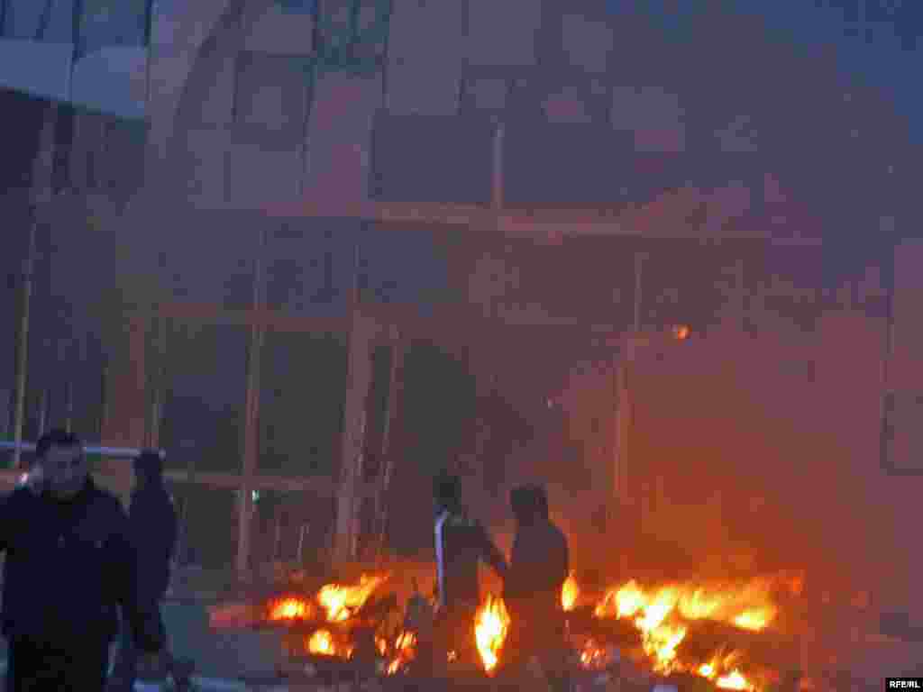 Fires burn near a damaged building in central Bishkek.