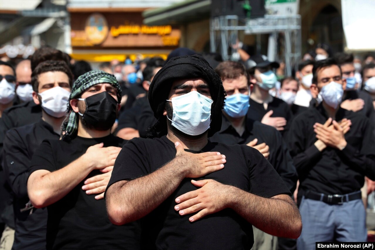 Believers in face masks beat their chests during the annual ceremony commemorating Ashura on August 30.