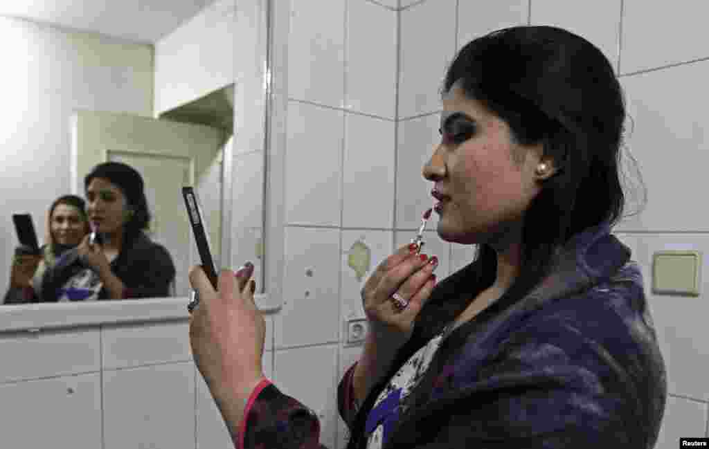 An Afghan model applies makeup before presenting creations designed by Afghan women at a fashion show launched by Young Women for Change in Kabul. (Reuters/Omar Sobhani)