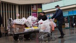 Мужчина толкает тележку с продуктами и туалетной бумагой в районе Зеленого базара.