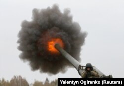 Український військовий під час пострілу самохідної гаубиці 2С7 «Піон» на полігоні на Київщині, 21 жовтня 2016 року