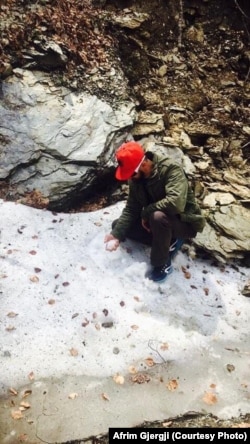 Afrim Gjergji pranë një prej shpellave të zonës ku gjithmonë ka borë.