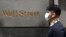 Un bărbat cu mască trece pe Wall Street, în timp ce pandemia de coronavirus a cuprins New York-ul