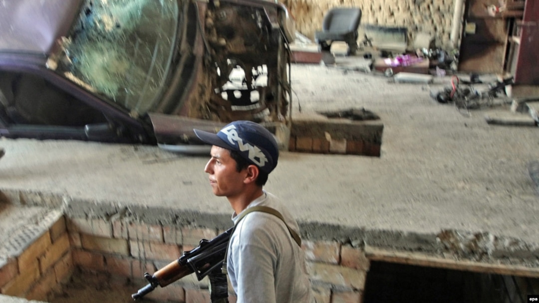 A police serviceman searching a house in an ethnic Uzbek district of Osh during the June violence in Kyrgyzstan.