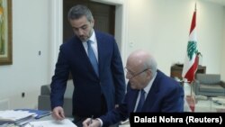 نجیب میقاتی (نشسته) نخست‌وزیر لبنان از تصمیم این دو گروه برای پایان دادن به تحریم کابینه خود استقبال کرده است.