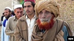 Pakistanis displaced from South Waziristan wait to get relief at a camp in Dera Ismail Khan.