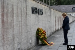 Germania - Cancelarul Angela Merkel în timpul unei ceremonii de depunere de coroane de flori la zidul Memorialului lagărului de concentrare din Dachau - 20 august 2013