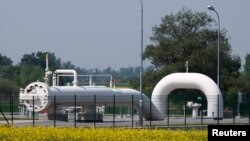 Gas pipes are pictured behind a field of rapeseed at Austria's largest natural-gas import and distribution station in Baumgarten.