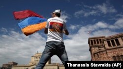 ARMENIA -- A man waves an Armenian flag at the Republic Square in Yerevan, Tuesday, May 8, 2018.