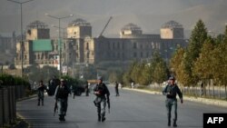 Afghan security personnel walk near the site of an attack by militants that targeted the elite American University of Afghanistan, in Kabul, on August 25, 2016.