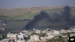 Dim iznad kuća nakon što su izraelski doseljenici zapalili imanja palestinskih seljana u selu al-Mughayyir na Zapadnoj obali, u subotu, 13. aprila 2024.