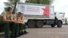 New Russian soldiers sit next to a mobile recruitment center for military service in Rostov-on-Don, Russia, in September 2022. 