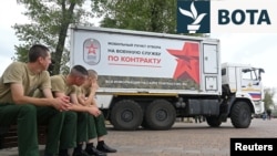 Ushtarë të rinj rusë të ulur pranë një qendre mobile rekrutimi për shërbim ushtarak në Rostov-on-Don, Rusi, në shtator 2022.