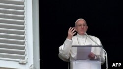 Pope Francis gestures as he speaks during the Angelus prayer in Saint Peter's