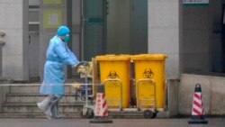 Medicinski tehničar odlaže pribor koji je vjerojatno inficiran novim korona virusom, Wuhan, 22. siječnja