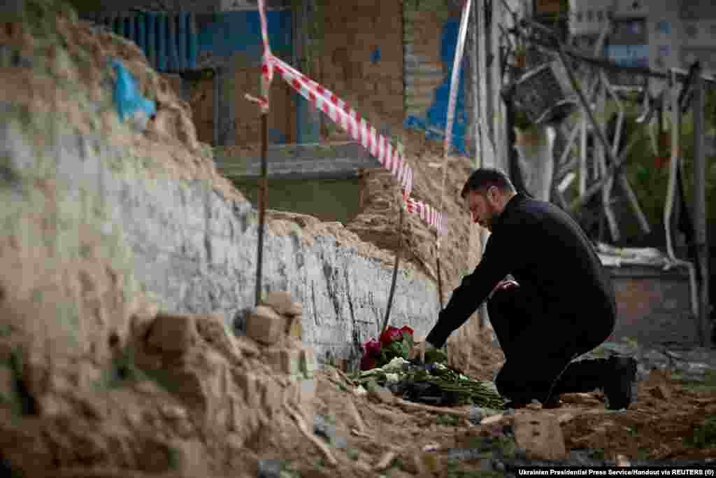 President Volodymyr Zelenskiy pays his respects to those were were killed when part of a Kyiv apartment block collapsed during a massive Russian drone and missile attack on the Ukrainian capital on July 17.