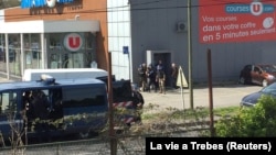 Police are seen at the scene of an apparent hostage situation in Trebes, France, on March 23.
