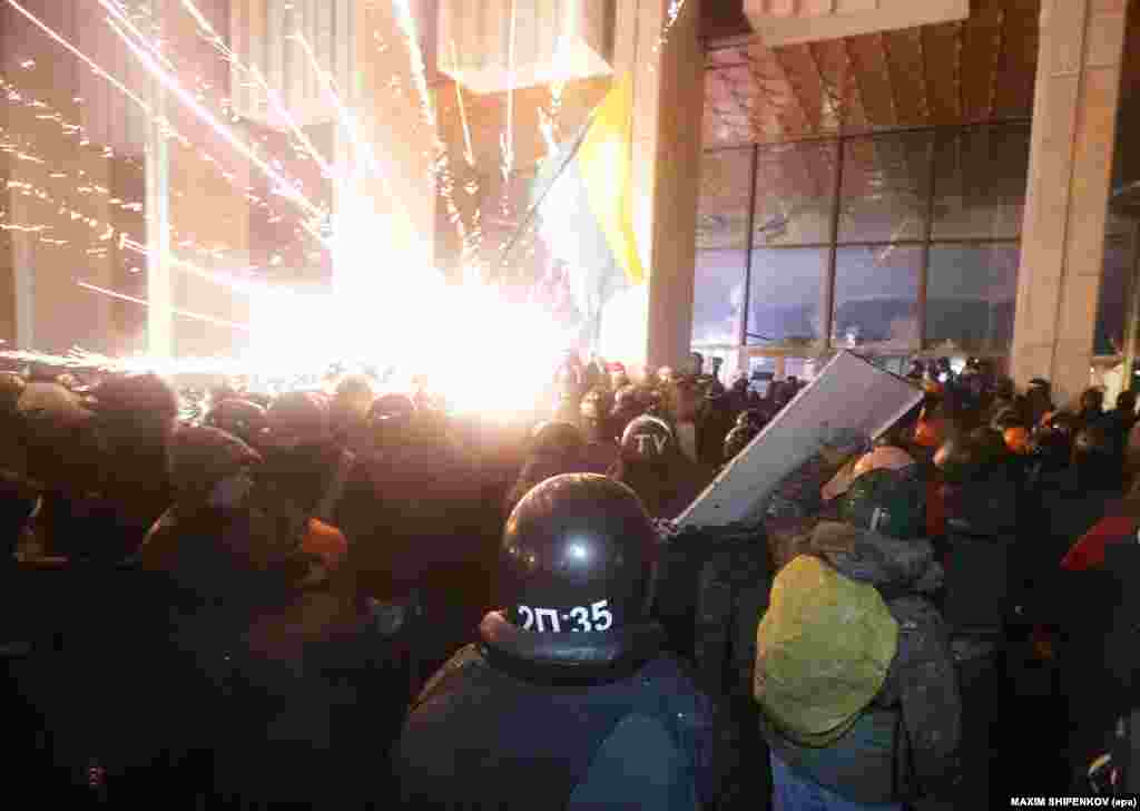 Protesters storm Ukrainian House, where dozens of riot police were based during an antigovernment protest in downtown Kyiv.