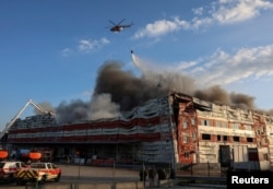 Vatrogasni helikopter baca vodu iznad mjesta ruskog raketnog napada u Kijevskoj oblasti rano 19. jula.