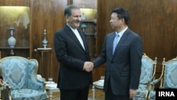 Vice president of Iran (left) Es'hagh Jahangiri shakes hands with the head of the International Liaison Department of the Communist Party of China, Son Tao on July 29, 2019.