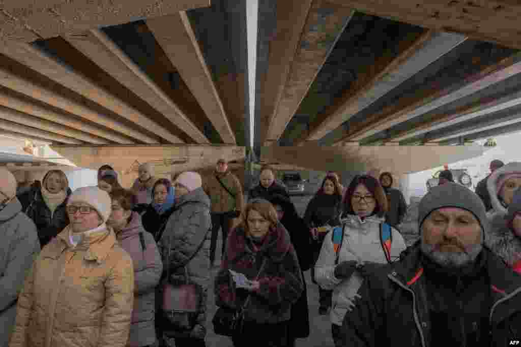 Local residents attend a memorial ceremony under a destroyed bridge in Irpin, northwest of Kyiv, on the anniversary of Russia's full-scale invasion of Ukraine on February 24. 