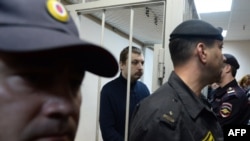 Mikhail Kosenko stands in a defendant's cage in a court in Moscow on October 8.
