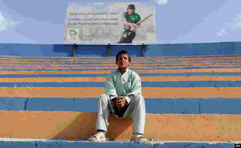 An Afghan youth watches a regional cricket tournament in Kabul on May 29. (AFP/Aref Karimi)